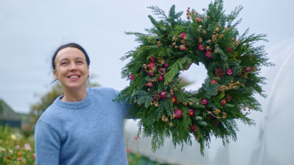Clem Richards - Head Florist at Heart of BS13 - proudly holds up her gorgeous prototype of the festive wreaths